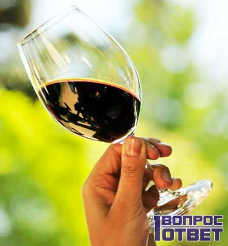 Наклоненный бокал с вином в руке