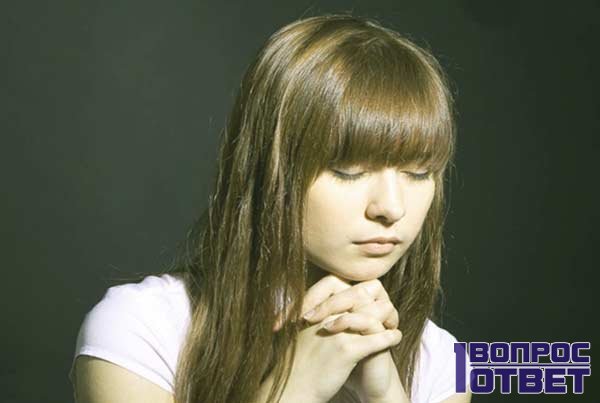 Девушка молится перед церковью